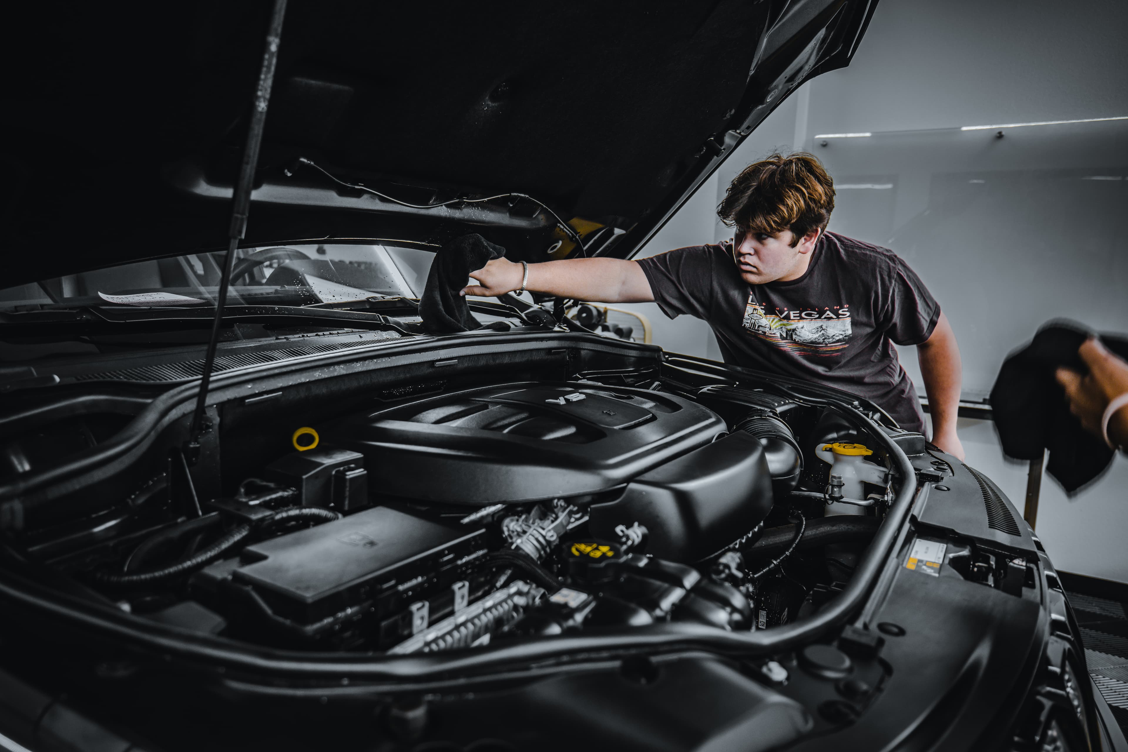 A student reconditioning a vehicle by hand during hands-on automotive training