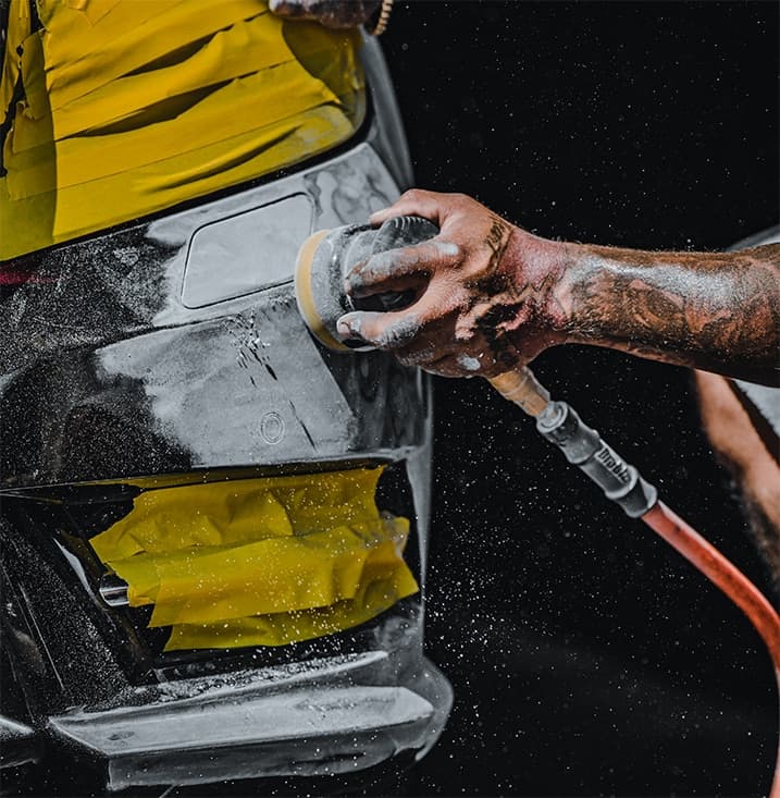 Sanding a scuffed bumper to prepare it for cosmetic repair