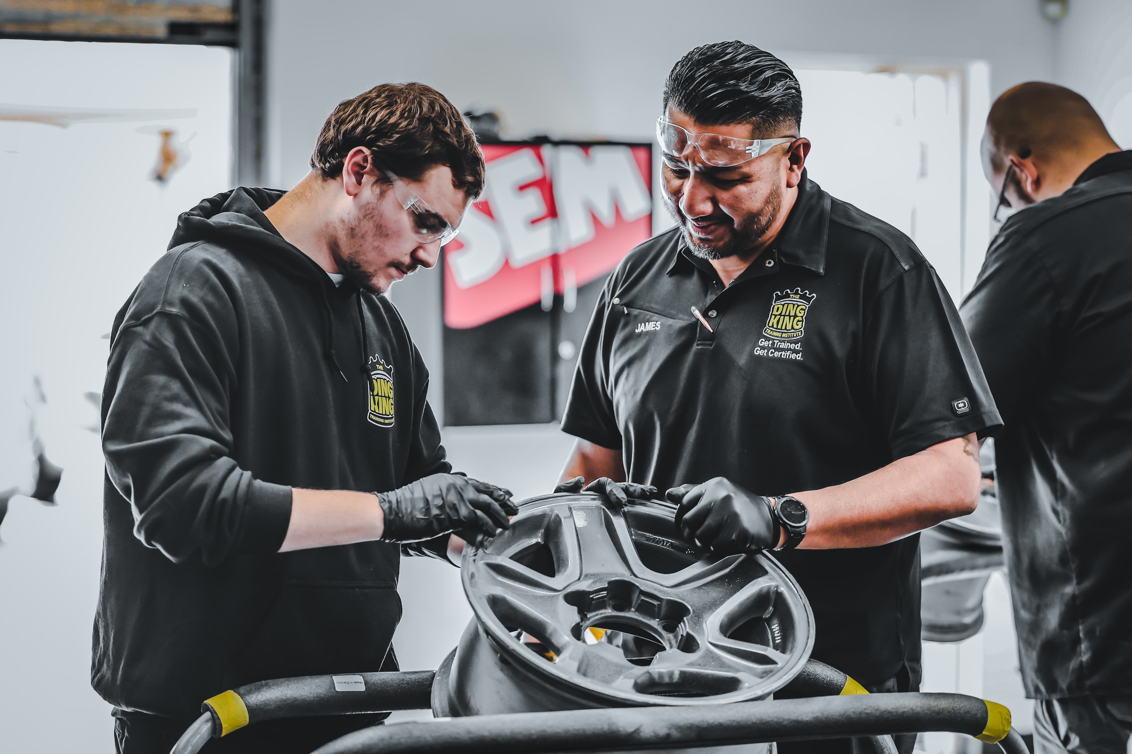 An instructor guiding a veteran through hands-on wheel reconditioning