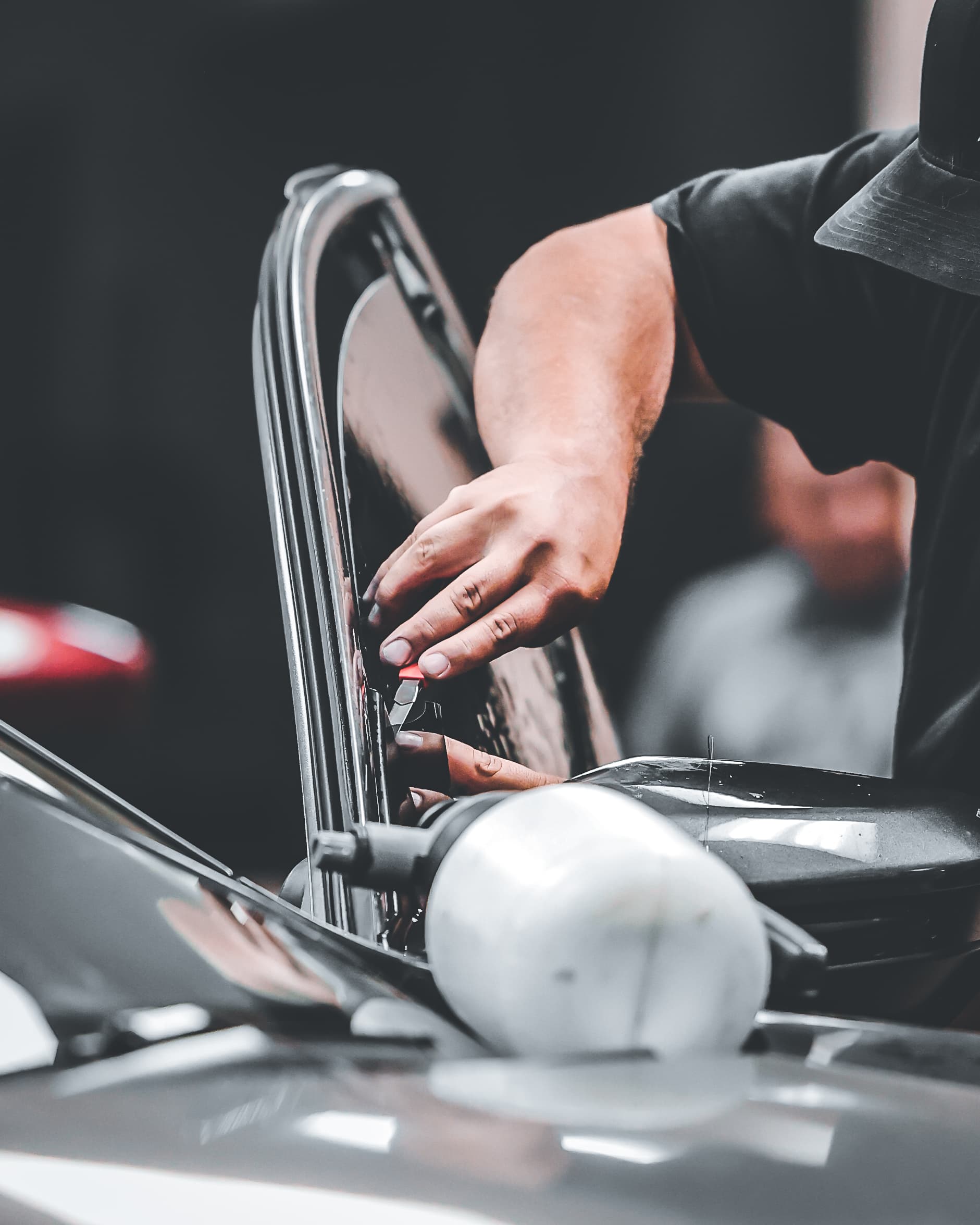 A technician applying window tint film to vehicle glass